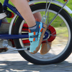 Kind trägt Sizeless Reef Kinderschuhe beim Fahrradfahren mit flexibler Sohle und gutem Halt
