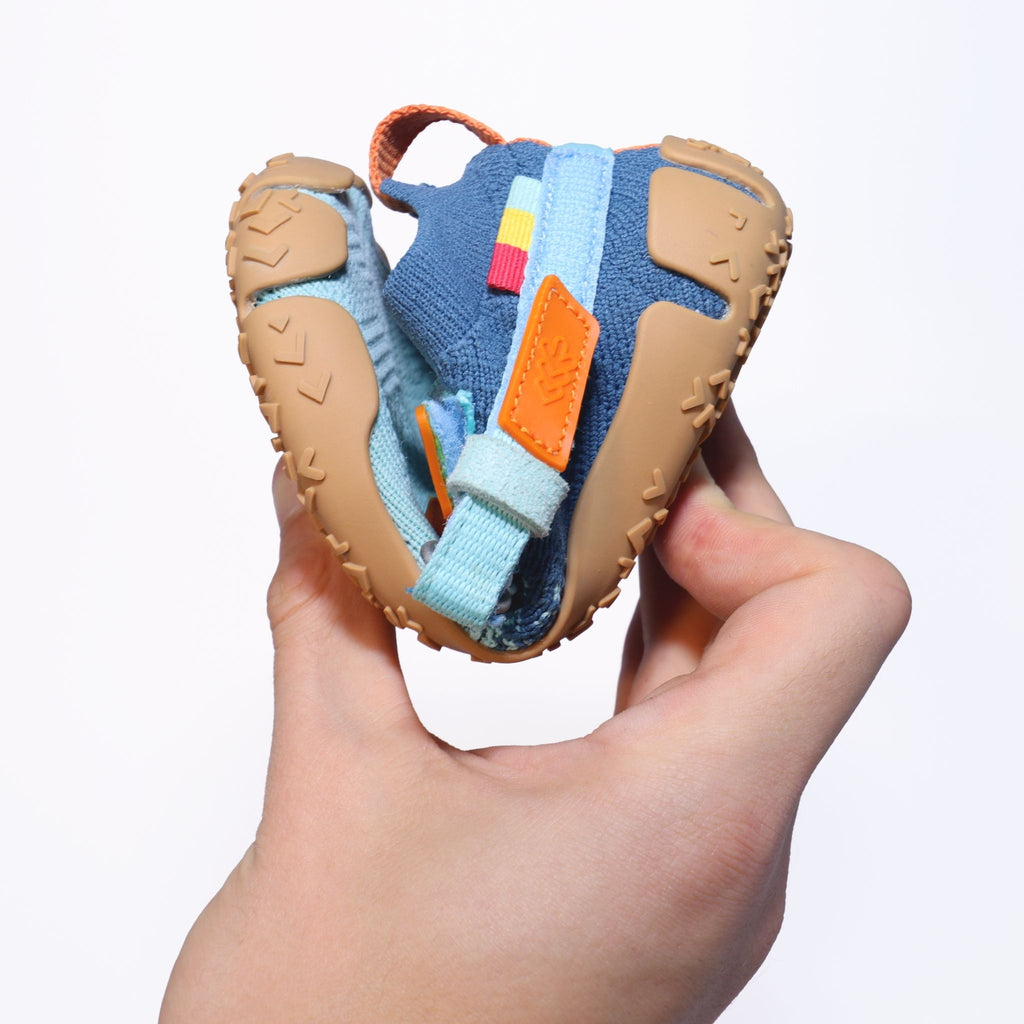 Sizeless Reef Kinderschuh wird gebogen und zeigt die flexible Sohle für natürliche Fußbewegung