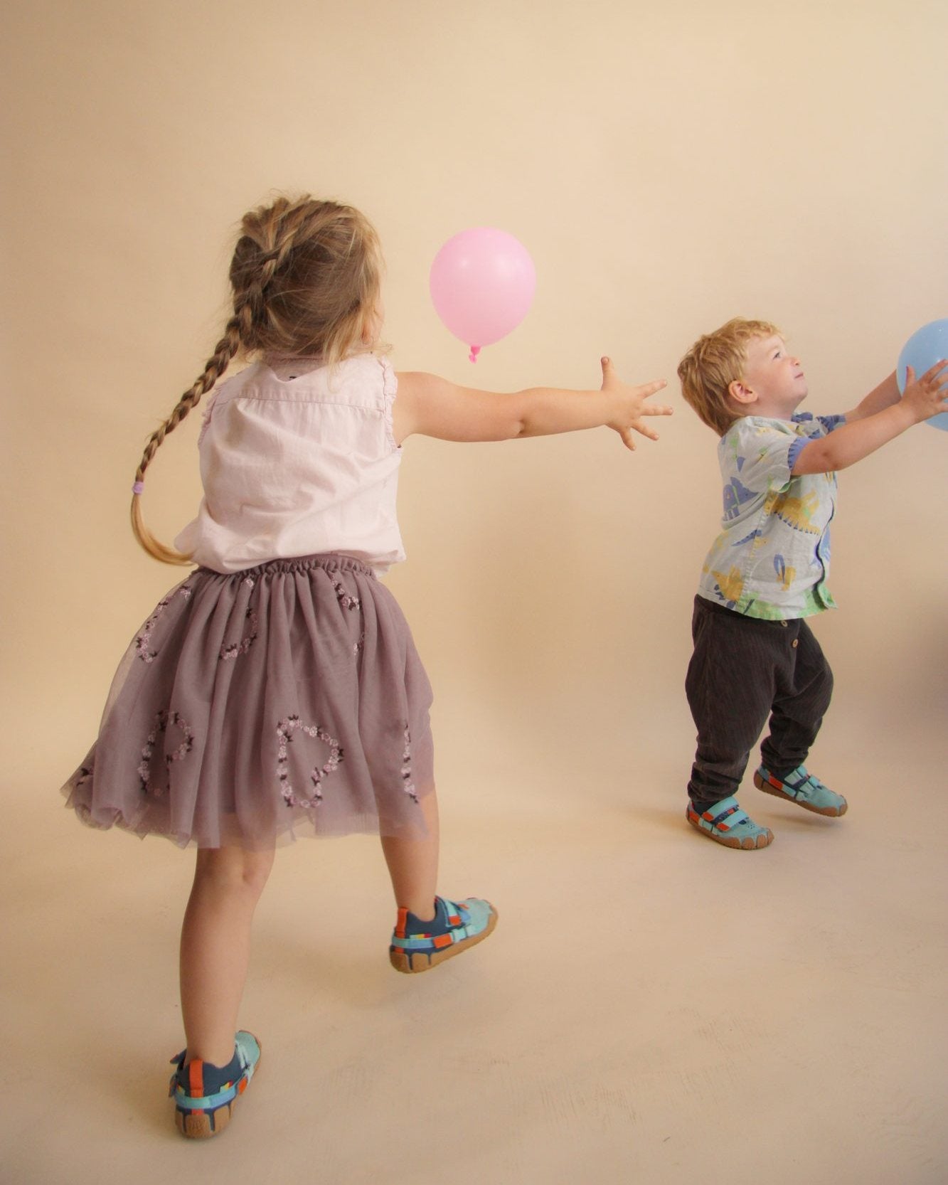 Zwei Kinder spielen mit Luftballons und tragen Sizeless Schuhe