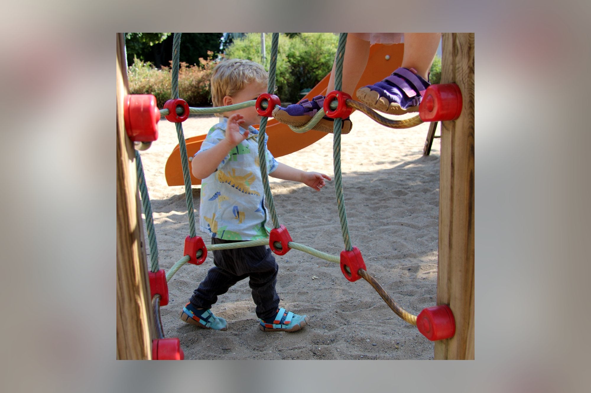 Junge am Kletternetz auf dem Spielplatz in Sizeless Reef